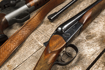 Many hunting rifles on weathered wooden surface