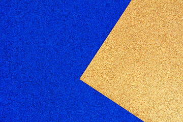 Shiny textured rich blue and gold glitter paper background