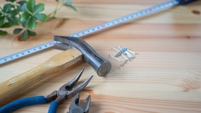 DIY工具イメージ。金槌と釘。ペンチとメカニックプライヤーと巻尺。