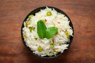 Close-up of Indian Basmati steamed Rice or matar (Pea) pulao or Pulav garnished with fresh green...