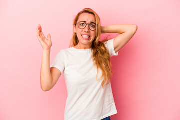 Caucasian blonde woman isolated on pink background screaming with rage.
