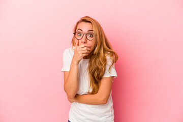 Caucasian blonde woman isolated on pink background scared and afraid.