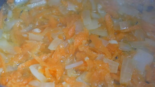 Sliced onion and carrot fried in sunflower oil close up