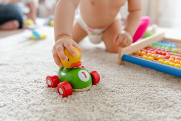 Baby playing with a wooden car