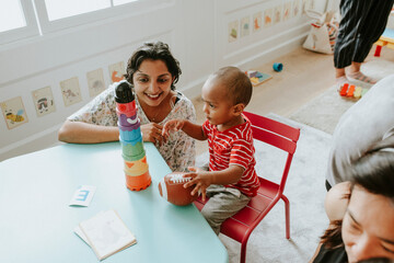 Child playing with a teacher in the nursery - obrazy, fototapety, plakaty