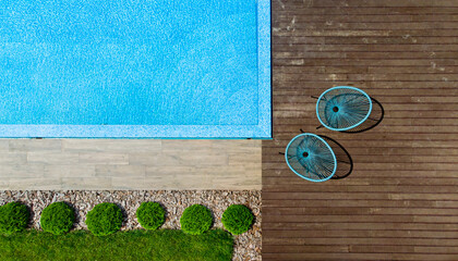 Fragment of modern luxury pool and wooden terrace. Landscaping background. Top view from drone.