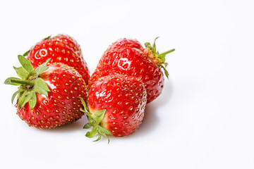 Close-up ripe and tasty strawberries on a white background. Sweet red juicy strawberries. Organic farmers fat-free, low-calorie food. Copy space. Seasonal antioxidant and detox nutrient.