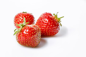 Sweet juicy strawberries. Group ripe and tasty strawberries on a white background. Organic farmers food. Copy space. Seasonal antioxidant and detox nutrient. Cholesterol-free, low-calorie food.