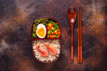 Healthy lunch in wooden japanese bento box.