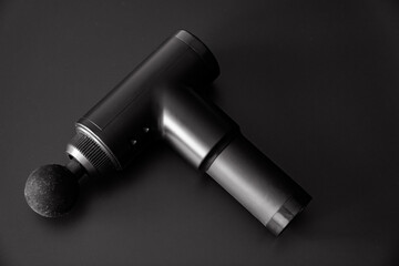 massage gun on a black background. medical-sports device.