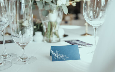Wedding reception table in the restaurant decorated with white candles and flowers. Close up the set of table in some romantic place