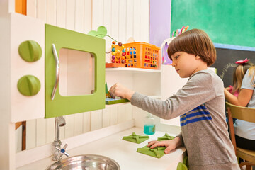 Junge beim Putzen und Aufräumen in der Küche