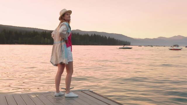 slow motion woman enjoying sunset on lake Tahoe with scenic pink sunset light 4K