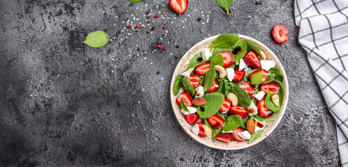 Diet menu. Healthy salad of fresh strawberry, spinach leaves, nuts and feta cheese, balsamic vinegar. Vegan food. Long banner format. top view