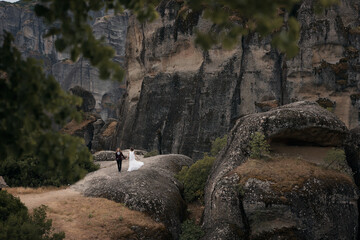 Obraz premium wedding photo shoot of a young couple on a background of green trees in the mountains