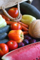 Straw bag and various seasonal fruit and vegetable. Selective focus.
