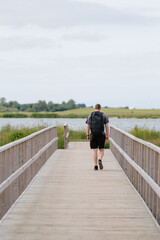 Hiker / trekker walking down bridge during summer