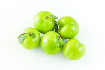 Green plums on white background, copy space, fruit, food concept, top view.