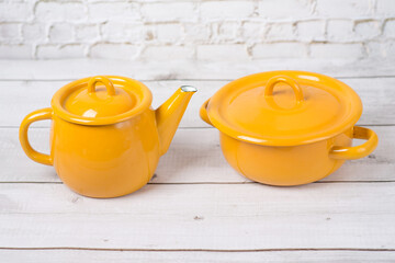 enamel pot and kettle. small light yellow enamel metal iron pot with top cover and handle in vintage retro style