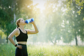 Close up of a adult woman drinking water from a sport shaker.