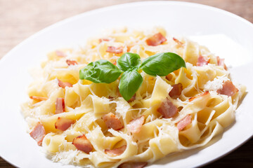 plate of pasta carbonara with basil