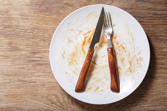 Empty Dirty Plate On A Wooden Table