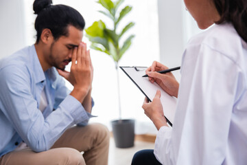 Professional psychologist woman conducting a consultation and talk with Asian man patient