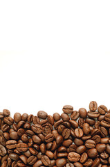 Fototapeta premium Pile of roasted coffee beans on white background with free space for text and design