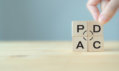Plan do check action concept , PDCA on wooden cube block with grey background ;copy space.  Deming cycle concept business management method to control and continuous improvement of process and product