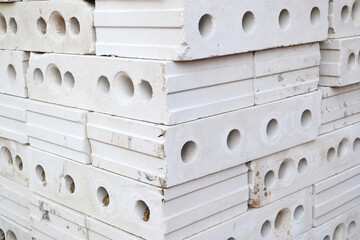 Gypsum hollow pazogrebnevye plates for partitions or internal walls are stacked in a pile on a construction site. Construction materials.Bricks
