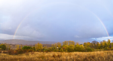 Fototapeta na wymiar Autumn landscape with full rainbow
