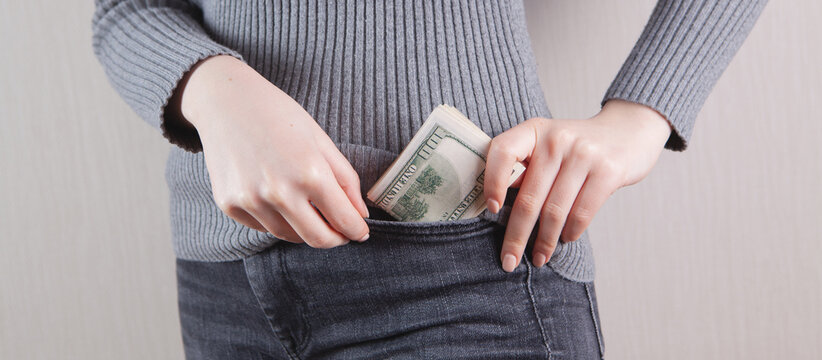 Woman Hand Putting Money In Jeans Pocket