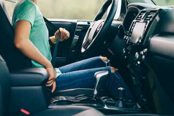 Woman driver buckle up the seat belt before driving car