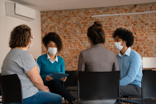 diverse business workgroup sharing thoughts and ideas with the team with face mask.