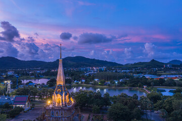 Fototapeta premium .aerial panorama view colorful cloud above pagoda of Chalong pagoda in twilight..beautiful architecture pagoda of Chalong temple in the night..colorful cloud scape sky sunset.