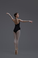 Ballet dancer in black tutu dancing inside studio
