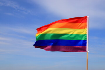 A beautiful rainbow flag of the LGBT organization flies in the sky. LGBT pride flags are used by lesbian, gay, bisexual, transgender and other people.