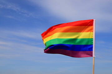 A beautiful rainbow flag of the LGBT organization flies in the sky. LGBT pride flags are used by lesbian, gay, bisexual, transgender and other people.