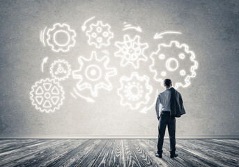 Obraz premium Cogwheel engine drawn on concrete wall as symbol for teamwork and cooperation