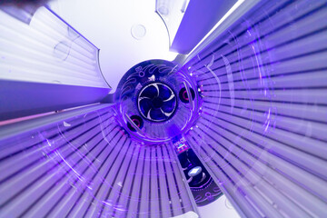 Close up of vertical solarium for tanning skin in spa salon, ultraviolet rays color - obrazy, fototapety, plakaty