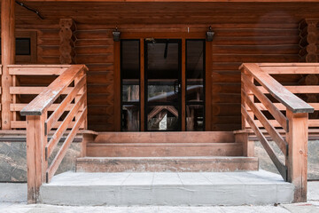 the porch of a log house made of wood in a pine forest
