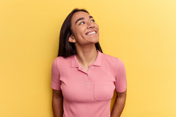 Fototapeta premium Young mixed race woman isolated on yellow background relaxed and happy laughing, neck stretched showing teeth.