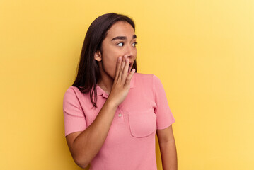 Young mixed race woman isolated on yellow background being shocked because of something she has seen.