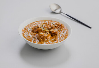 butter chicken served in a white bowl and copy space
