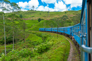Travel by public train around the island of Sri Lanka. The train travels through mountains and tea plantations. Scenic railway