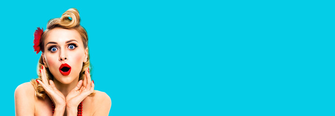 Image of excited surprised, very happy blondy hair woman. Pin up syle girl with opened mouth and raised hands. Retro and vintage concept. Aqua blue colour background. Wide composition.