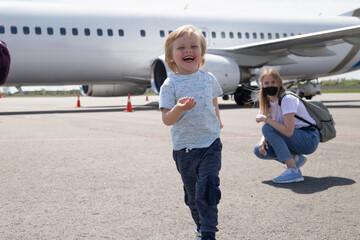 Happy family on the background of the plane. Child run away from his mom
