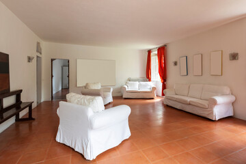Large living room with white armchairs and sofas. A bit decadent environment
