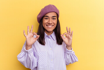 Young mixed race woman isolated on yellow background cheerful and confident showing ok gesture.