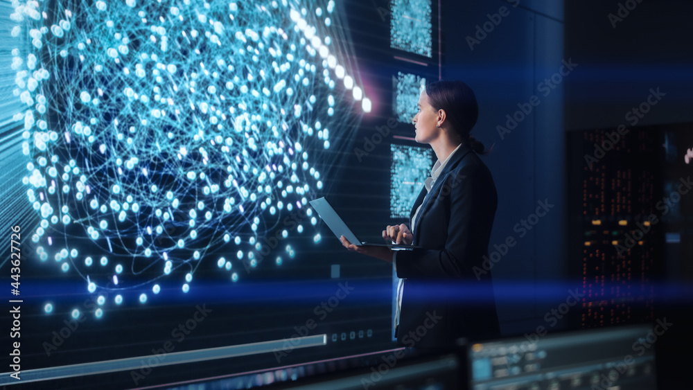 Poster Young Female Computer Science Engineer Working on Laptop next at Big Screen Display Showing Neural Data. Telecommunications Technology Company System Control and Monitoring Room with Servers.